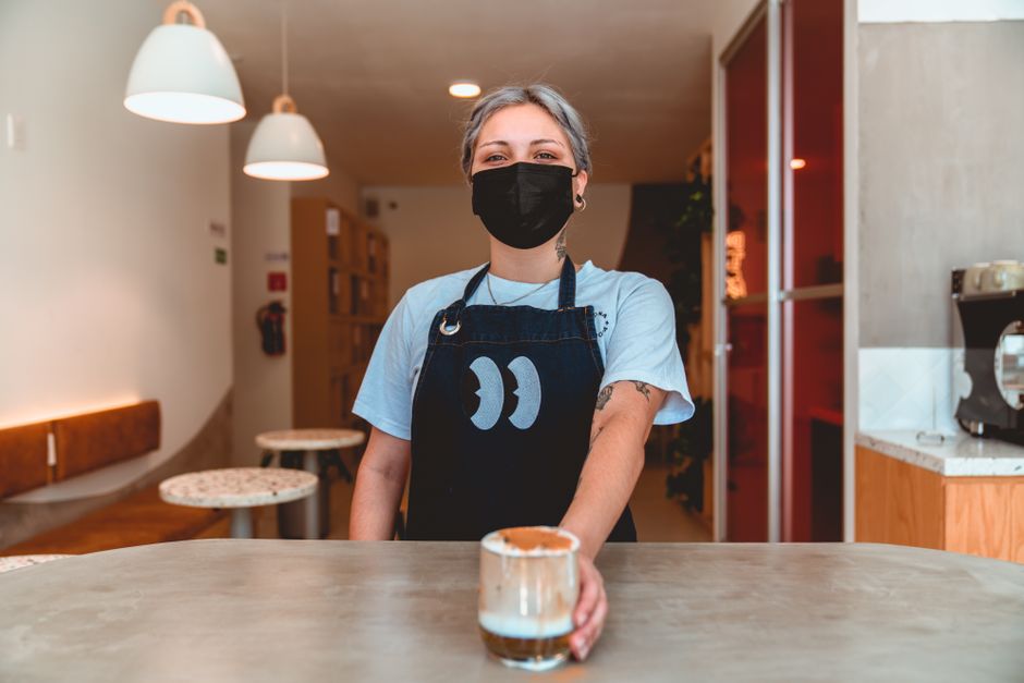Barista sirviendo café frío como referencia para menú digital en cafetería