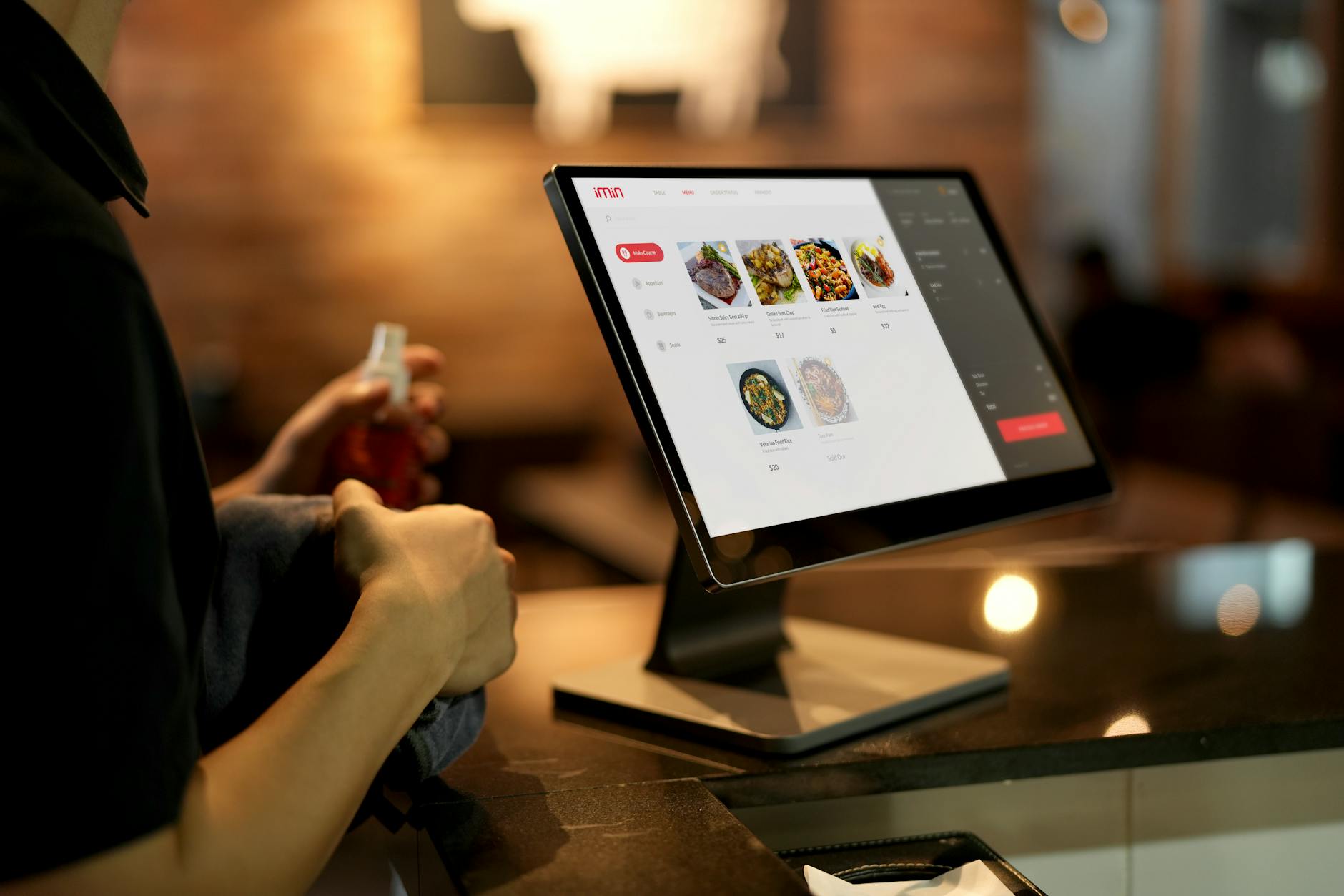 Person using a touchscreen ordering system in a modern restaurant