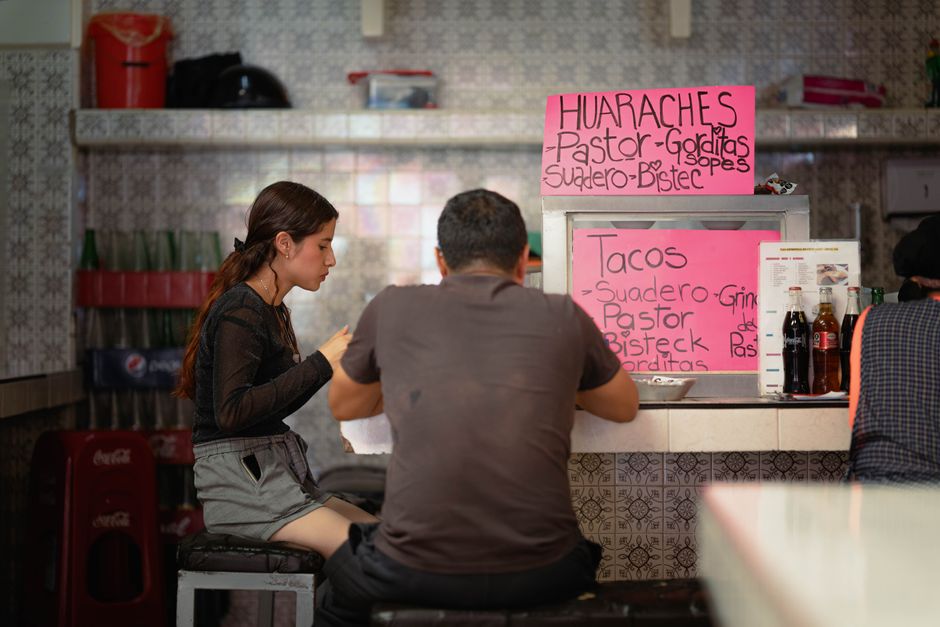 Customers seated at a taqueria counter for a no-hardware signage pilot