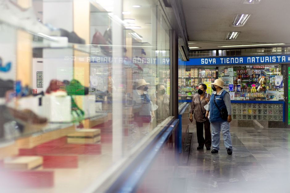 Visitantes recorriendo tiendas dentro de un centro comercial