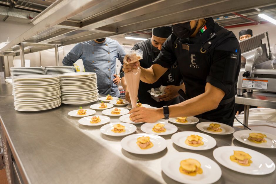Equipo de cocina coordinando platillos que deben coincidir con el menú mostrado al cliente