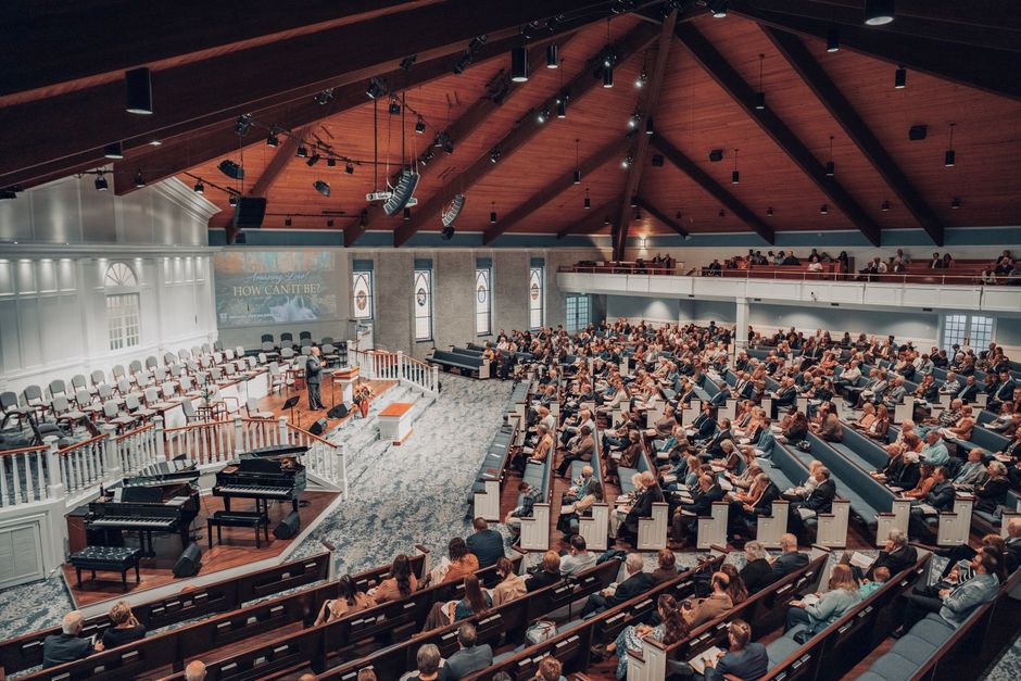 Congregation gathered in a church auditorium with a presentation screen visible
