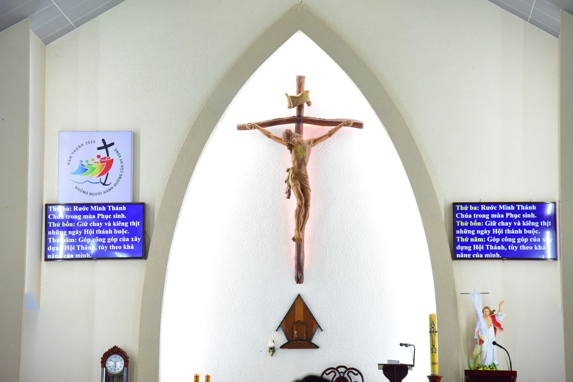 Church sanctuary with two digital information screens beside the altar