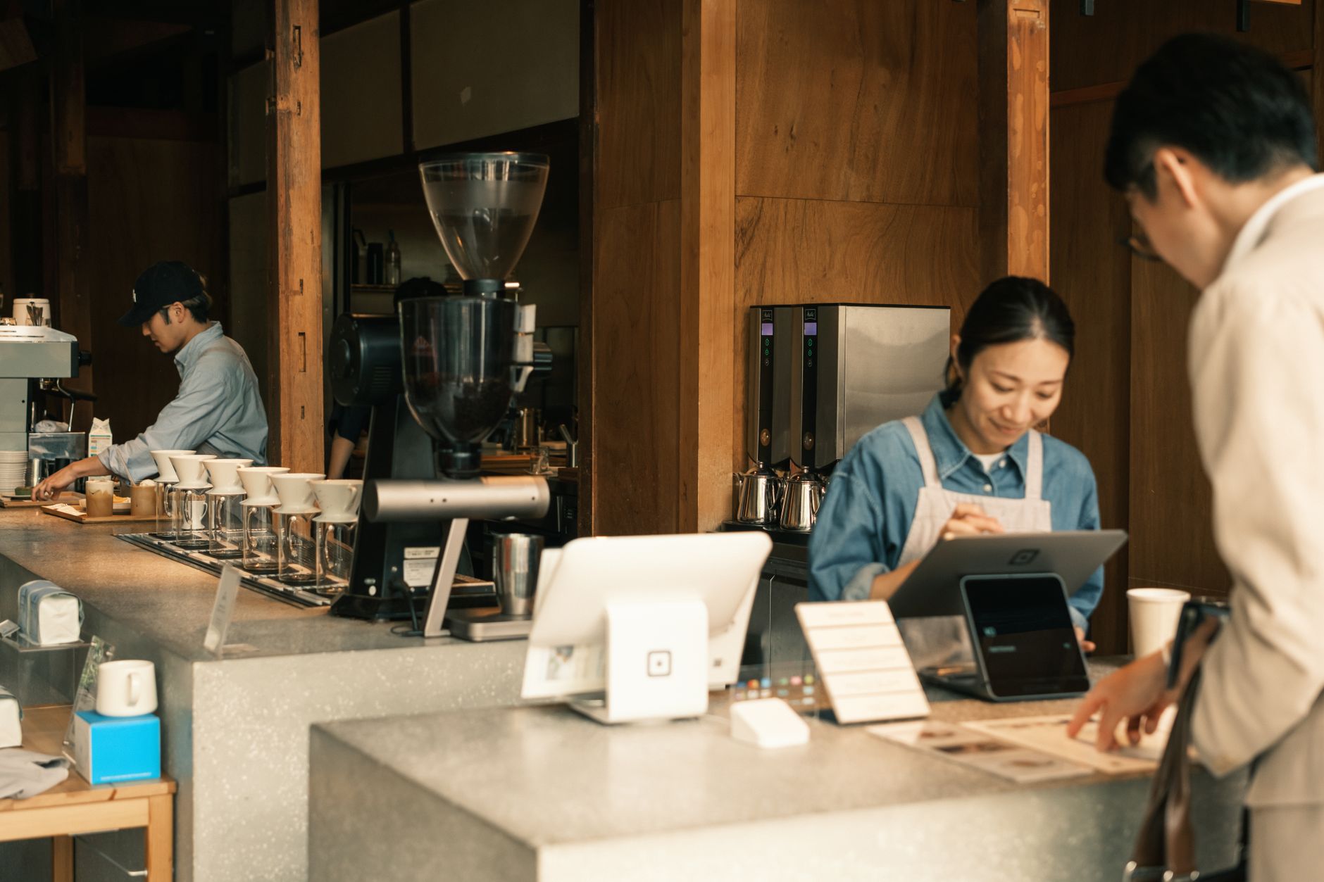 Friendly coffee shop team serving guests at a modern counter