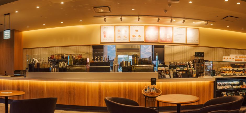 Wide café service counter with illuminated overhead menu displays