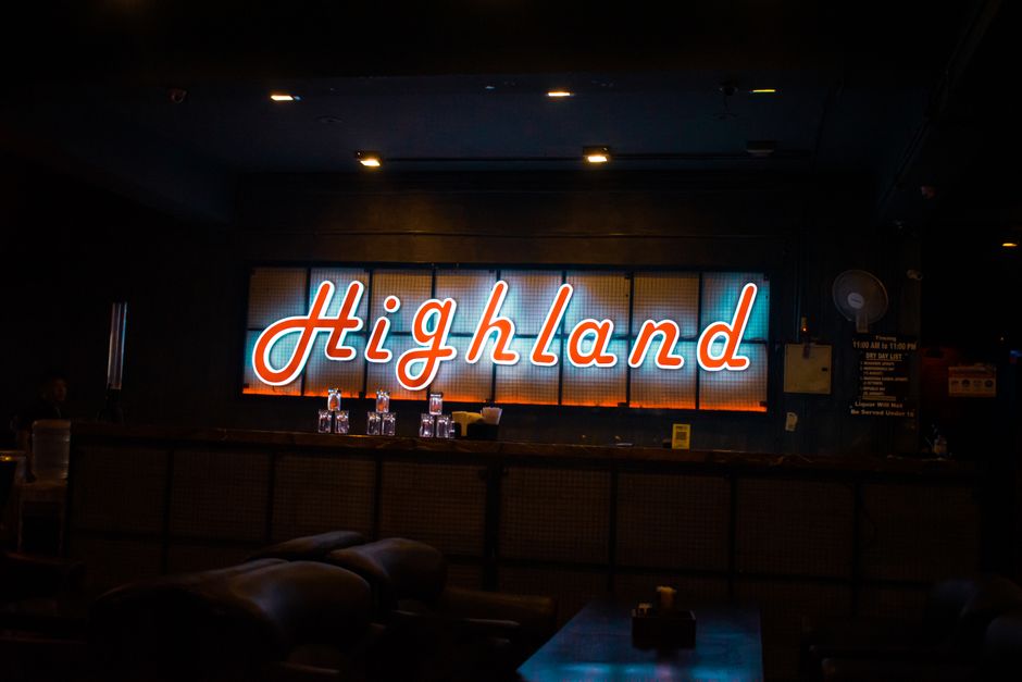 A dark hospitality bar with an illuminated sign