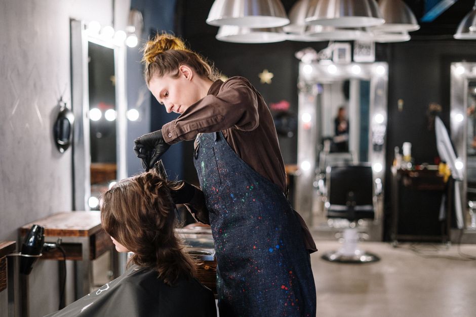 Salon professional preparing a client at a styling station