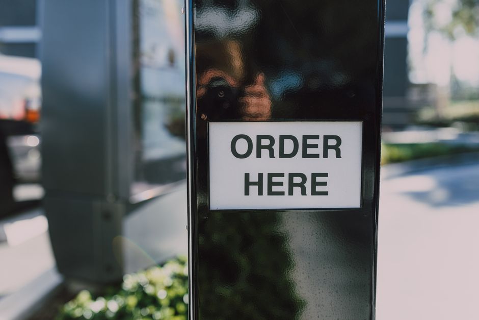 Order-here sign at a restaurant counter for signage placement planning