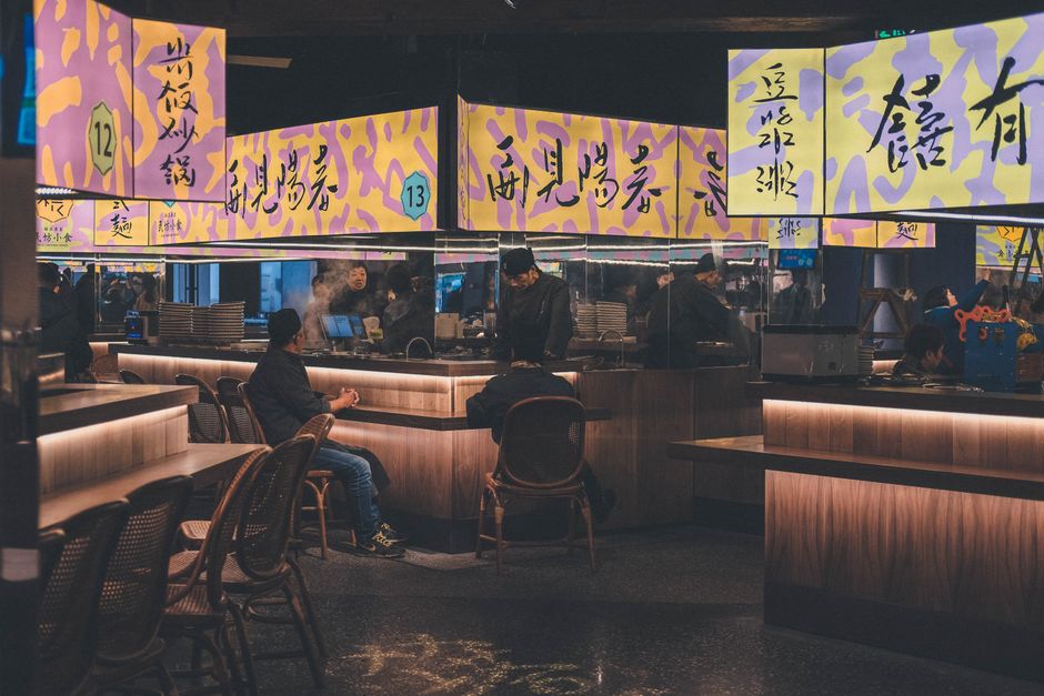 A restaurant interior with several illuminated display surfaces that require coordinated aspect ratios and content zones