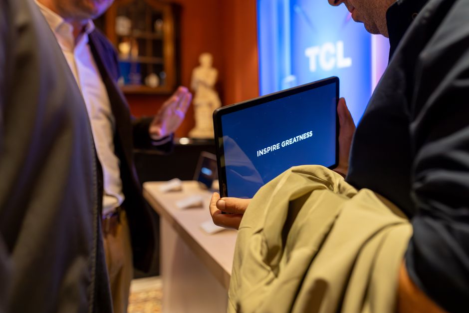 A person testing a tablet near a display, representing the pairing and verification step