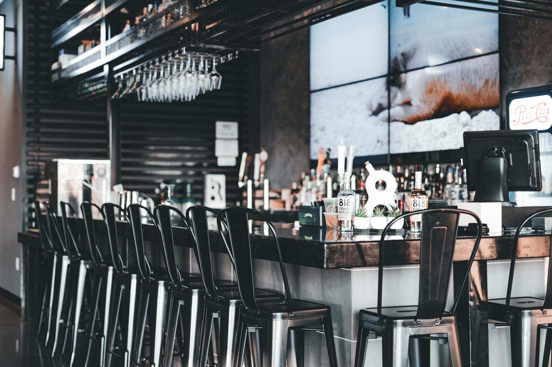 Restaurant bar with screens and high chairs prepared for live sports viewing