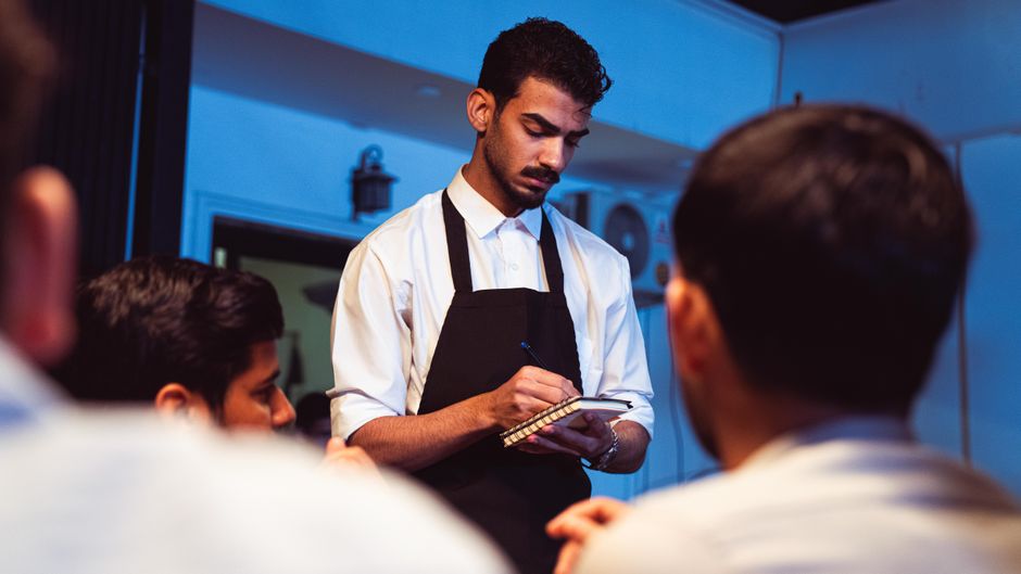 Mesero tomando una orden para revisar el flujo entre cliente y menu board