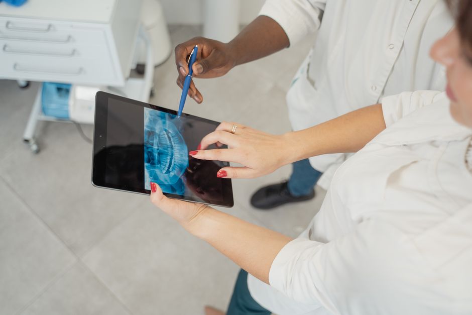 Odontóloga y paciente revisan una radiografía dental en una tablet