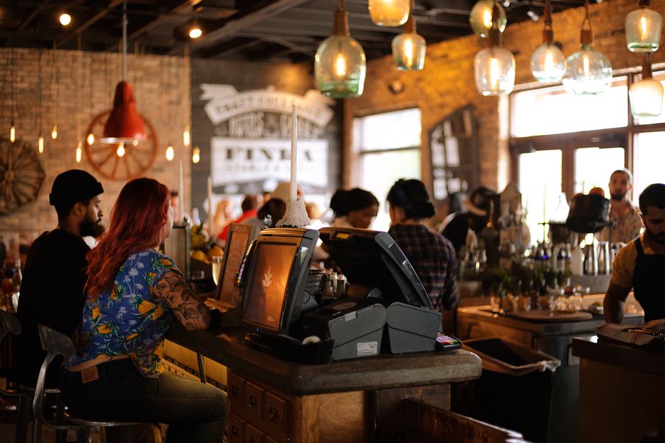 Bar concurrido con clientes y punto de venta en primer plano