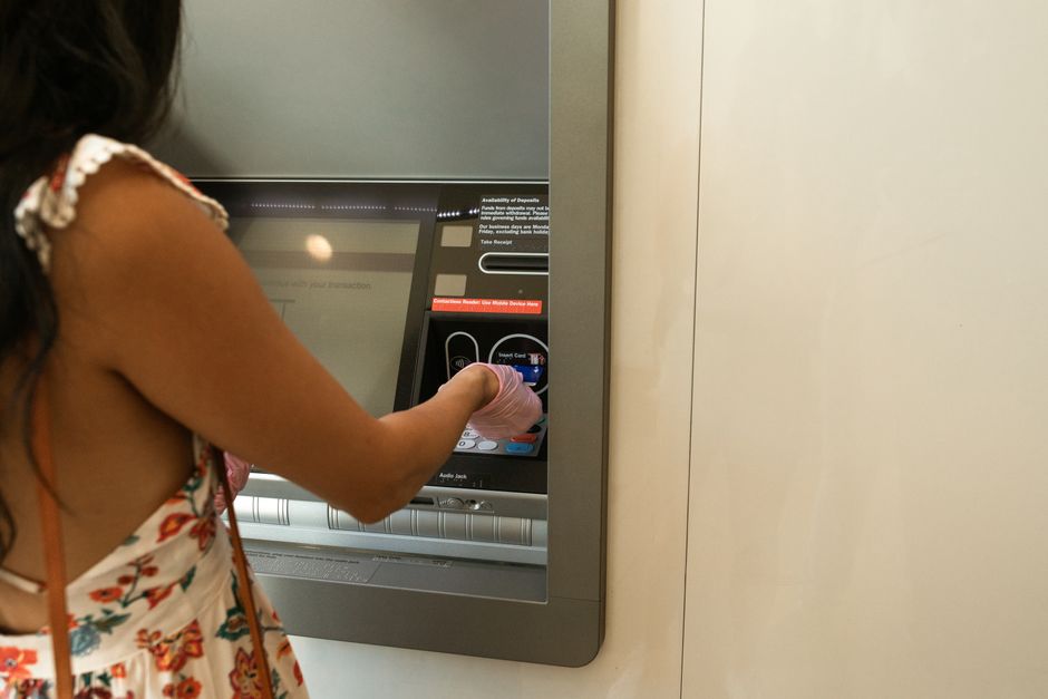 Clienta usando un cajero automático en una zona de autoservicio