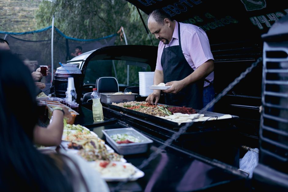 Operador de comida móvil preparando pedidos frente a clientes