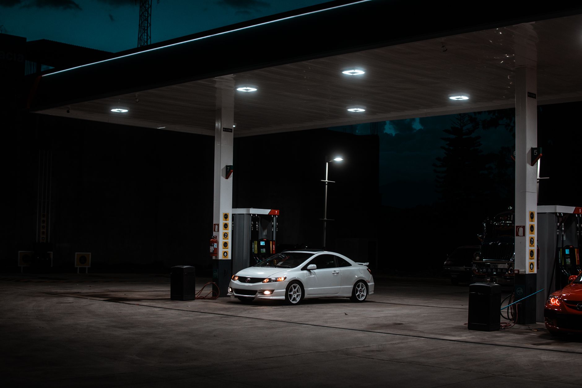 Gasolinera iluminada de noche para planear señalización digital visible