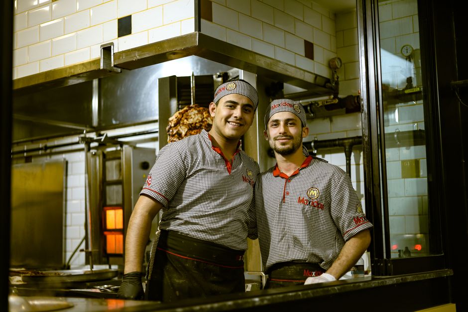 Equipo de cocina preparando servicio para coordinar menú y tableros digitales