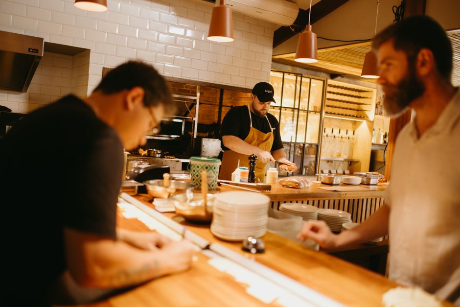 Food service team preparing dishes in an open restaurant kitchen